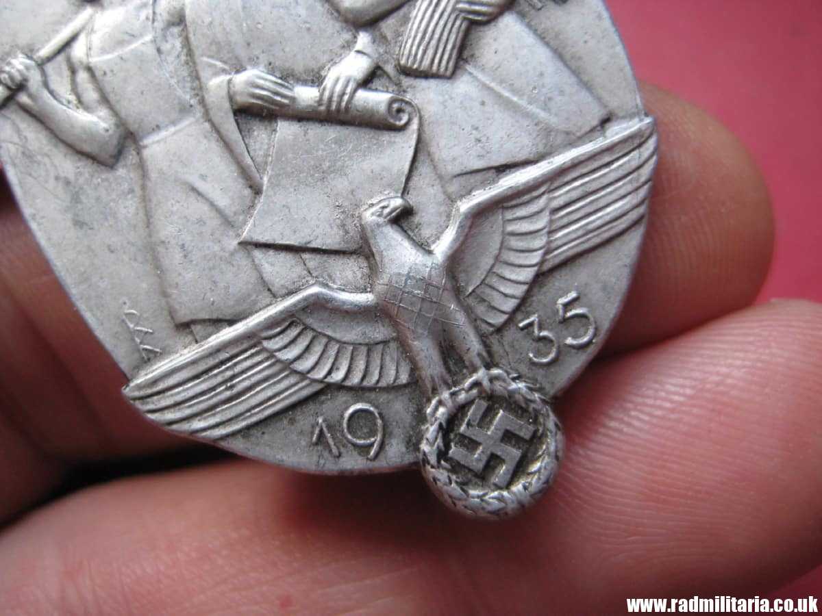 & WW2 original German TINNIE BADGE - Tag Der Arbeit 1935 marked: JFS - Josef Feix Sohne, Gablonz.